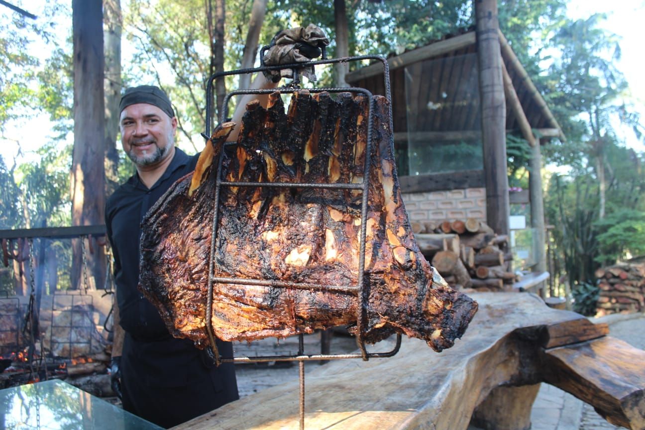 Churrasqueiro preparando as carnes na brasa