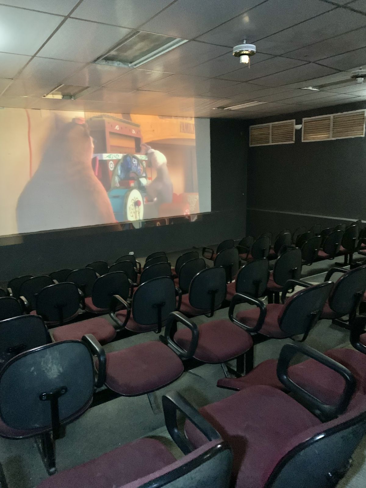 Sala de cinema com poltronas e telão